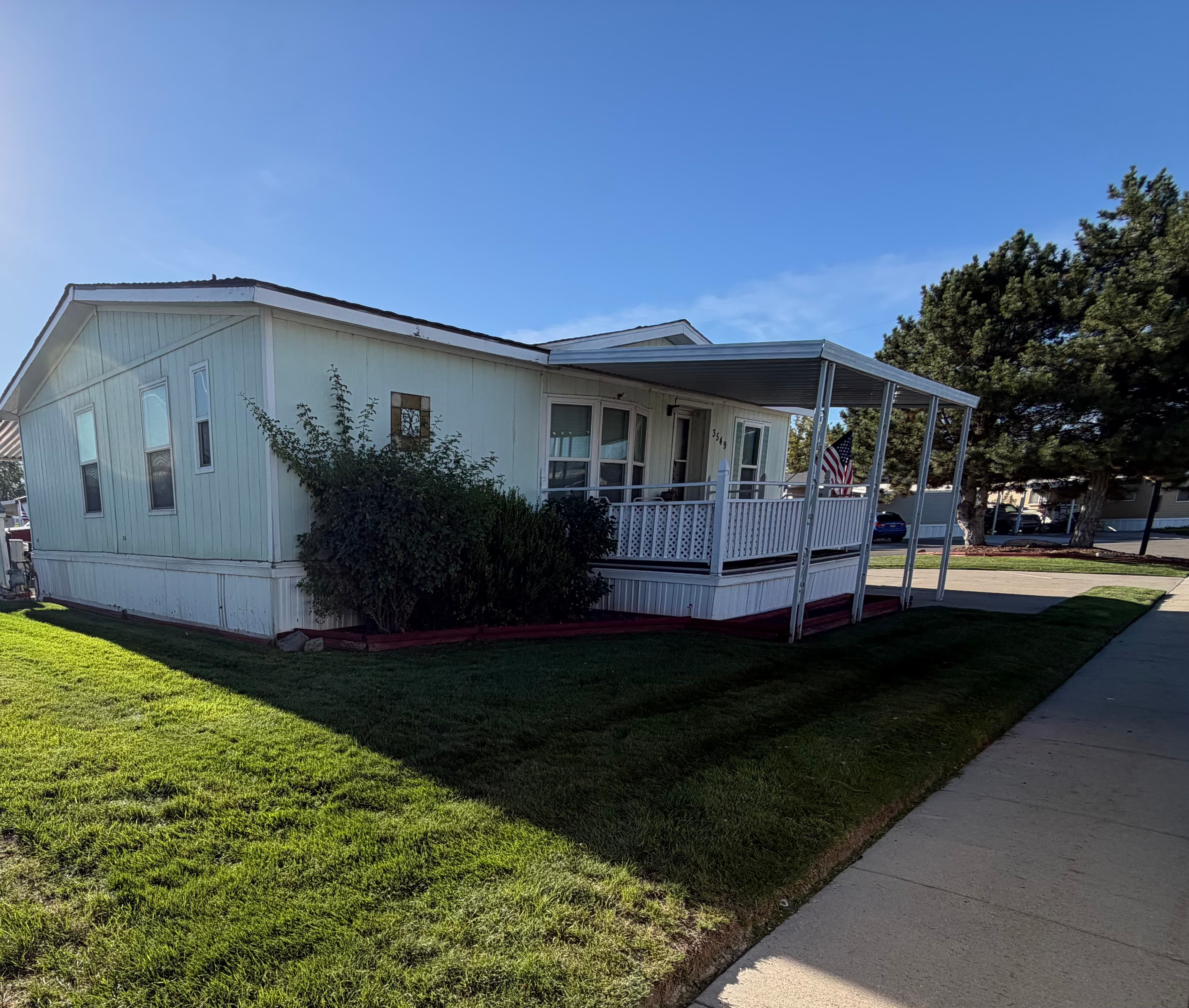 Freshly mowed lawn alongside a sidewalk and a home with a covered porch