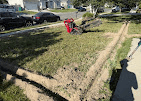 Trencher cutting sprinkler lines through a park strip lawn