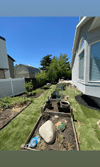 Side yard with newly built planting beds, boulders, and fresh sod